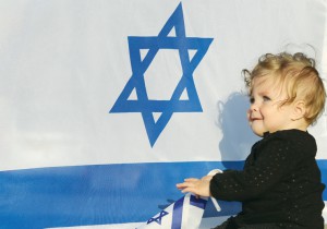 A baby sits in front of an Israeli flag. (photo credit:MARC ISRAEL SELLEM/THE JERUSALEM POST)